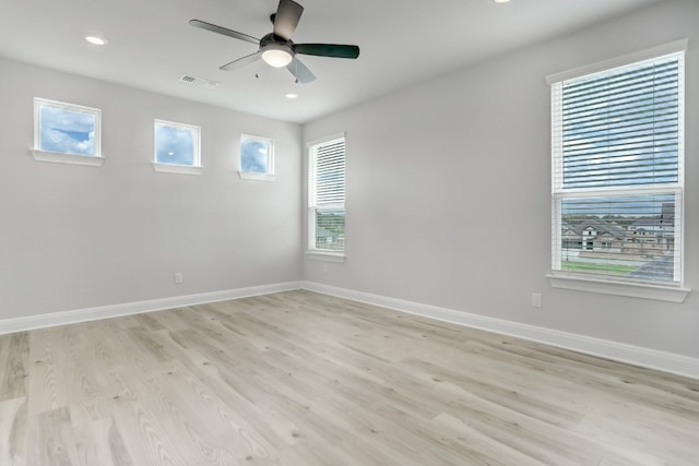 spare room with light wood-type flooring, baseboards, visible vents, and ceiling fan