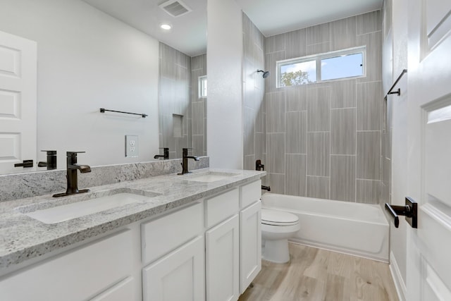 full bath featuring wood finished floors, a sink, visible vents, and shower / bathing tub combination