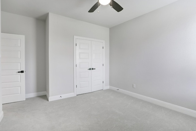 unfurnished bedroom with light carpet, a ceiling fan, baseboards, and a closet