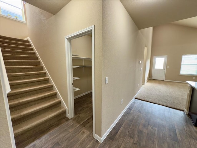 hallway with stairs, dark wood-style flooring, and baseboards