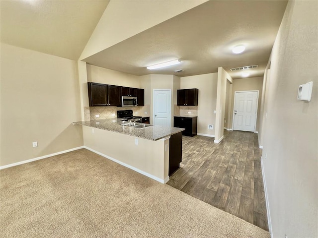 kitchen featuring electric range, visible vents, stainless steel microwave, a peninsula, and dark brown cabinets