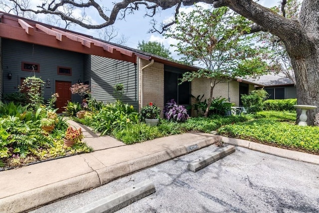 view of front of property featuring uncovered parking and brick siding