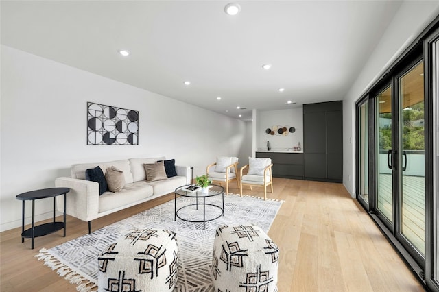 living room with baseboards, recessed lighting, and light wood-style floors