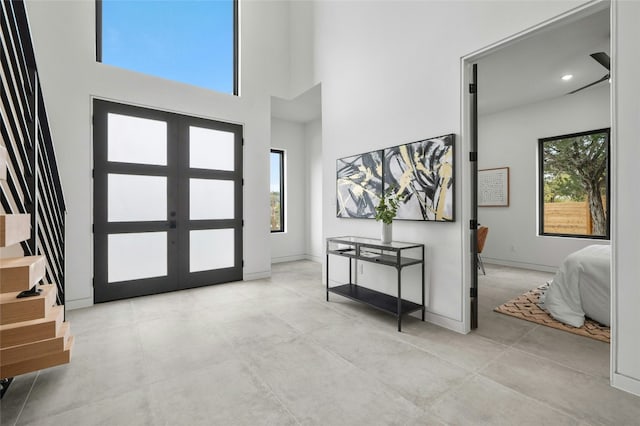 foyer with recessed lighting, french doors, baseboards, and a high ceiling