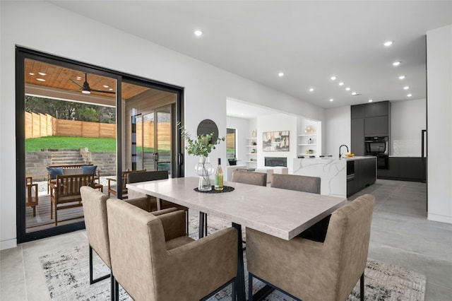 dining area with built in shelves, a fireplace, and recessed lighting