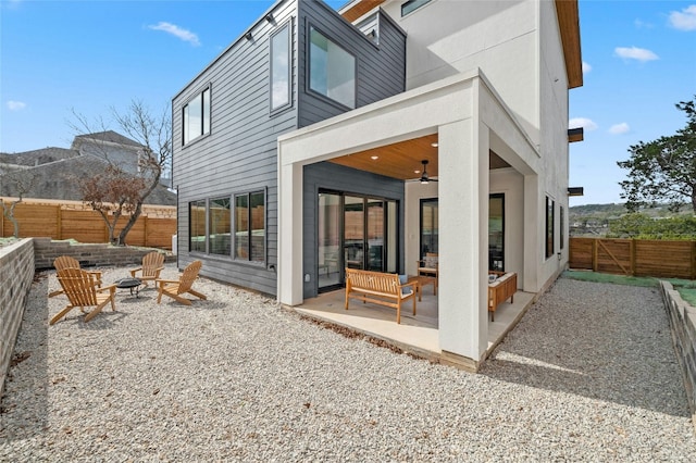 back of house featuring ceiling fan, a patio, a fire pit, and a fenced backyard