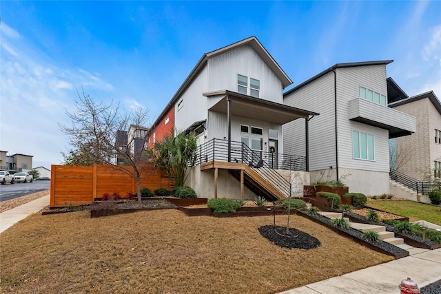 modern home with stairway and fence