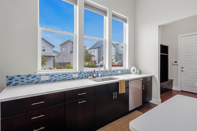 6221 Seville Dr, Austin, TX 78724 - kitchen with tasteful backsplash, a sink, light countertops, stainless steel dishwasher, and dark wood-style flooring