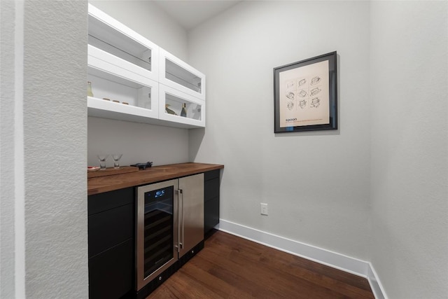 6221 Seville Dr, Austin, TX 78724 - bar with wine cooler, a dry bar, baseboards, and dark wood-style flooring