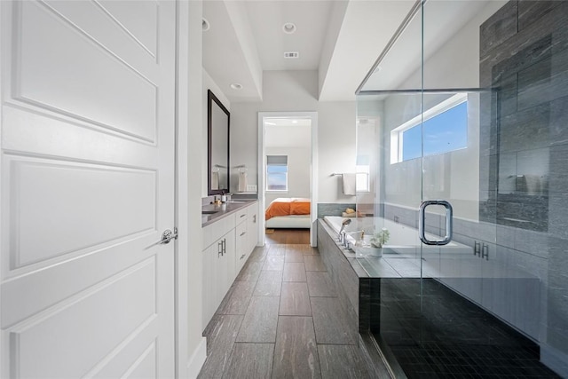 6221 Seville Dr, Austin, TX 78724 - ensuite bathroom featuring visible vents, wood finish floors, ensuite bath, a shower stall, and a bath