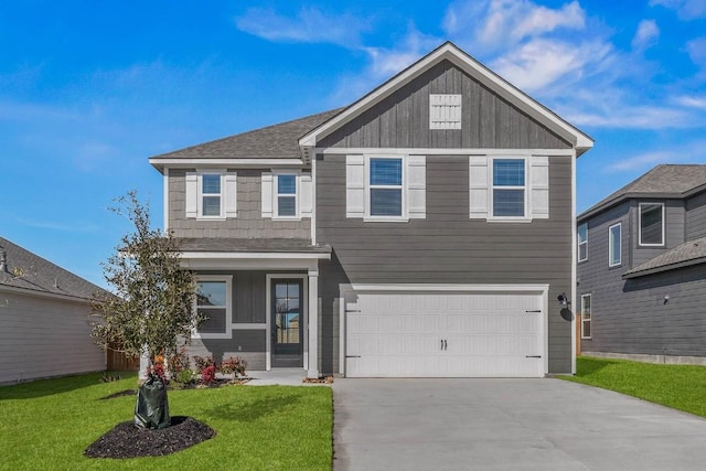 view of front facade with a garage, a shingled roof, concrete driveway, a front lawn, and board and batten siding