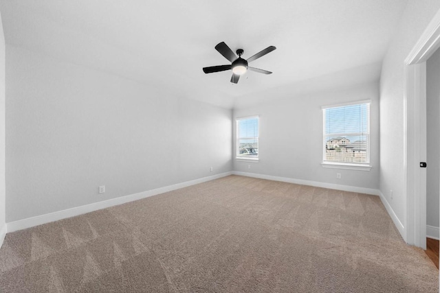 carpeted spare room featuring a ceiling fan and baseboards