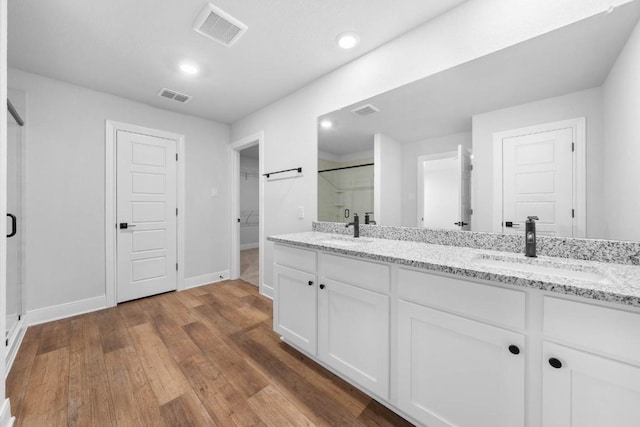 bathroom featuring a spacious closet, double vanity, a sink, and visible vents