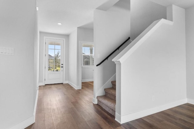 entrance foyer with dark wood-style floors, stairs, and baseboards