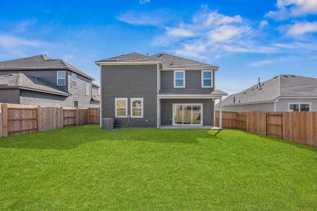 back of house featuring central air condition unit, a fenced backyard, and a yard