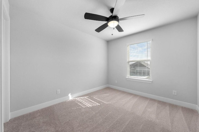 carpeted empty room with ceiling fan and baseboards