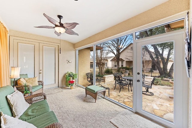 sunroom / solarium featuring a ceiling fan and french doors