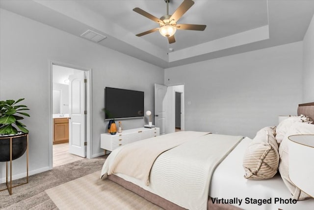 bedroom with baseboards, a raised ceiling, visible vents, and light colored carpet