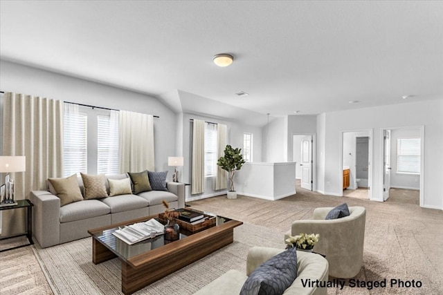 living area with light carpet, baseboards, and a wealth of natural light