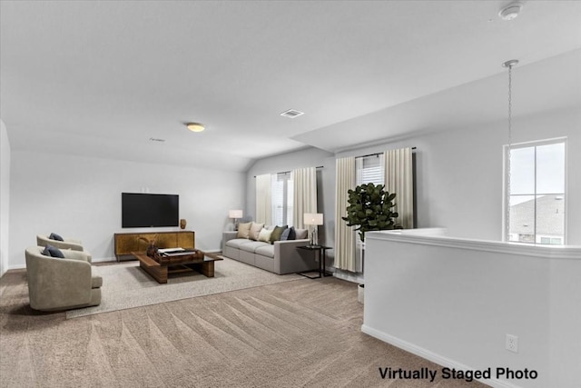 carpeted living area with lofted ceiling, visible vents, and baseboards