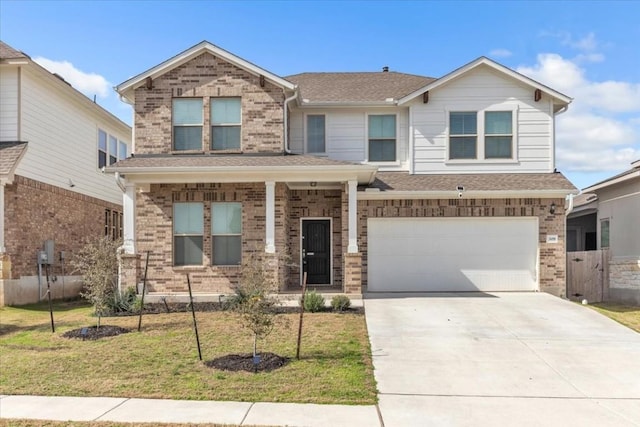 view of front of house featuring a front yard, brick siding, and driveway