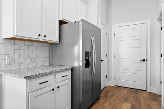 kitchen with light stone counters, dark wood finished floors, white cabinetry, and tasteful backsplash