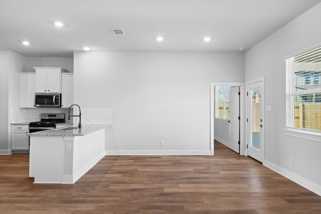 kitchen featuring a peninsula, white cabinetry, appliances with stainless steel finishes, and a sink