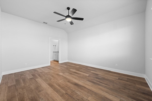 spare room with lofted ceiling, wood finished floors, a ceiling fan, visible vents, and baseboards