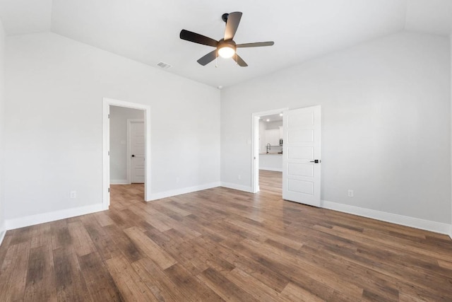 unfurnished room featuring vaulted ceiling, wood finished floors, visible vents, and baseboards