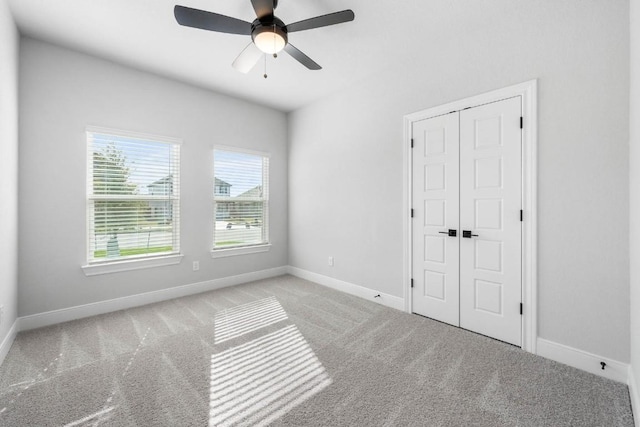 unfurnished bedroom featuring baseboards, a closet, and light colored carpet