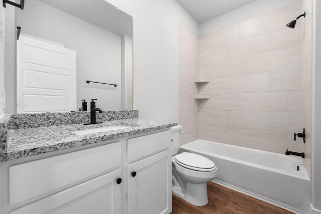 bathroom with toilet, vanity, shower / tub combination, and wood finished floors