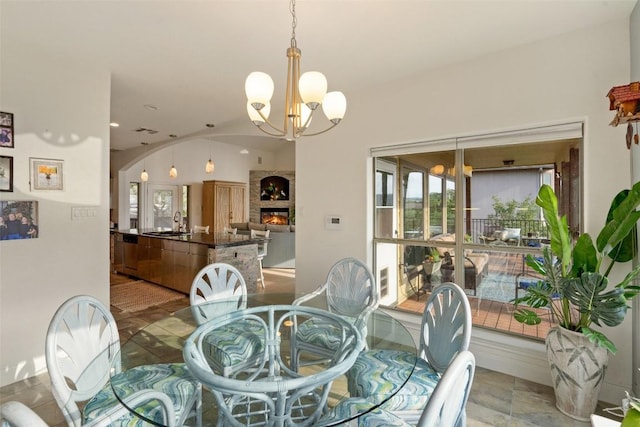 dining space featuring arched walkways, a warm lit fireplace, visible vents, and an inviting chandelier