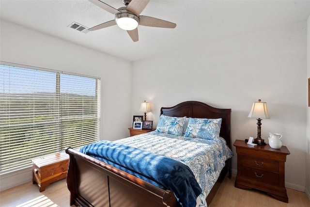 bedroom with visible vents, baseboards, light wood-style flooring, and a ceiling fan