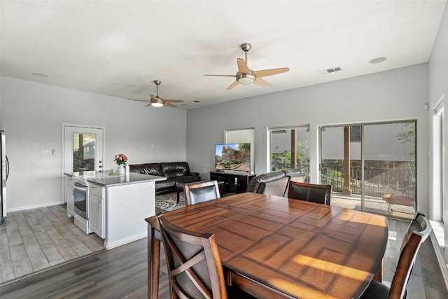 dining area featuring baseboards, dark wood-style flooring, visible vents, and a ceiling fan