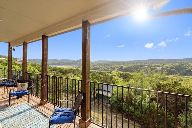 balcony featuring a mountain view and a wooded view