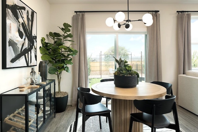 dining space featuring light wood-type flooring and an inviting chandelier