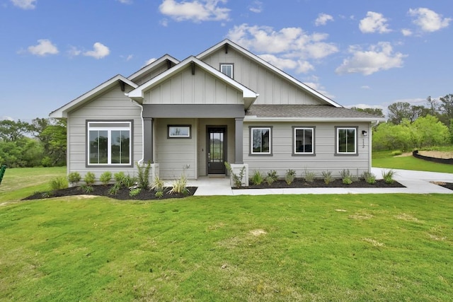 view of front facade featuring board and batten siding, a shingled roof, and a front lawn