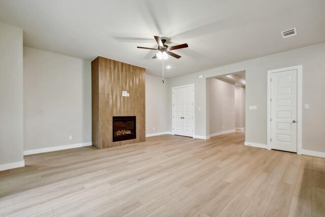 unfurnished living room with a ceiling fan, visible vents, a fireplace, light wood-type flooring, and baseboards