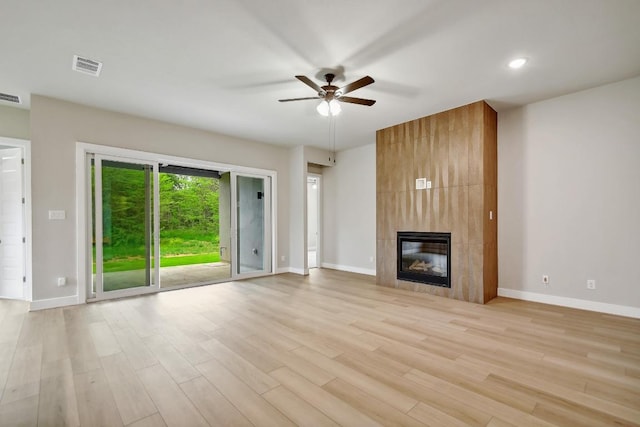 unfurnished living room featuring visible vents, light wood-style flooring, ceiling fan, and a fireplace
