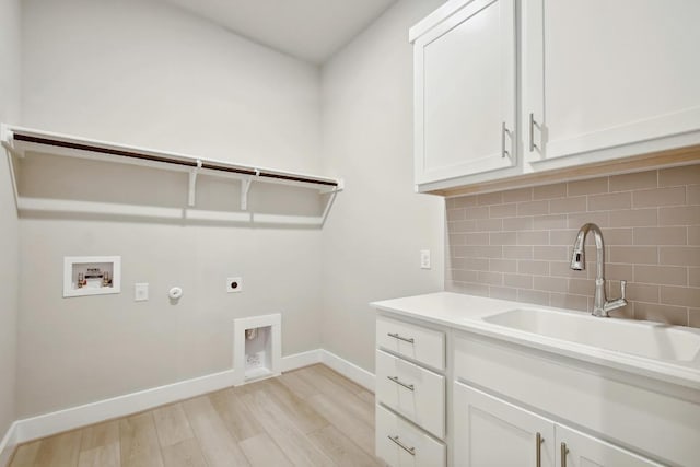 clothes washing area featuring washer hookup, hookup for an electric dryer, cabinet space, a sink, and light wood-style floors