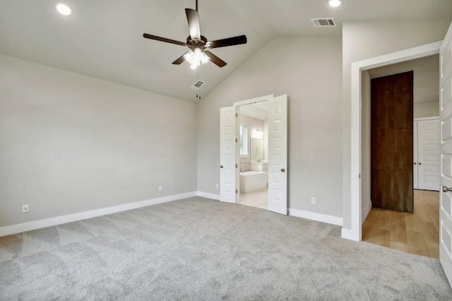 unfurnished bedroom with baseboards, light carpet, connected bathroom, and visible vents