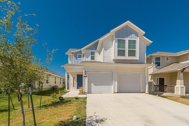 view of front facade featuring concrete driveway, a front lawn, board and batten siding, and an attached garage