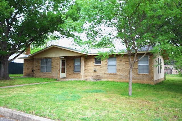 single story home with a front yard, fence, and brick siding