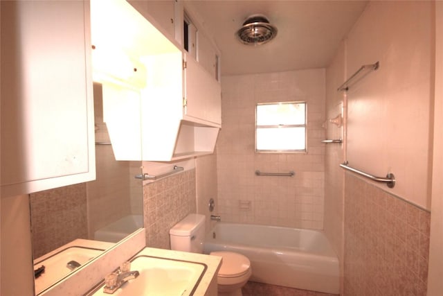 full bath with vanity, tile walls, toilet, and bathing tub / shower combination