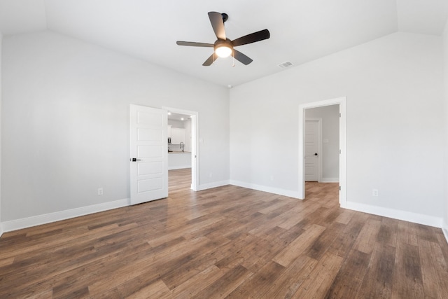 unfurnished bedroom with baseboards, visible vents, vaulted ceiling, and dark wood-style flooring