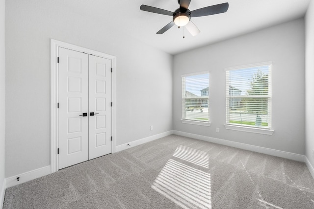 unfurnished bedroom with light carpet, a ceiling fan, baseboards, and a closet