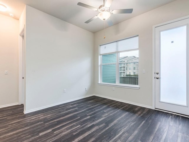 spare room featuring a ceiling fan, baseboards, and dark wood-style flooring