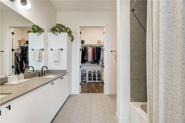 800 Embassy Dr Unit 319, Austin, TX 78702 - full bathroom with double vanity, a walk in closet, shower / bath combo with shower curtain, and tile patterned flooring