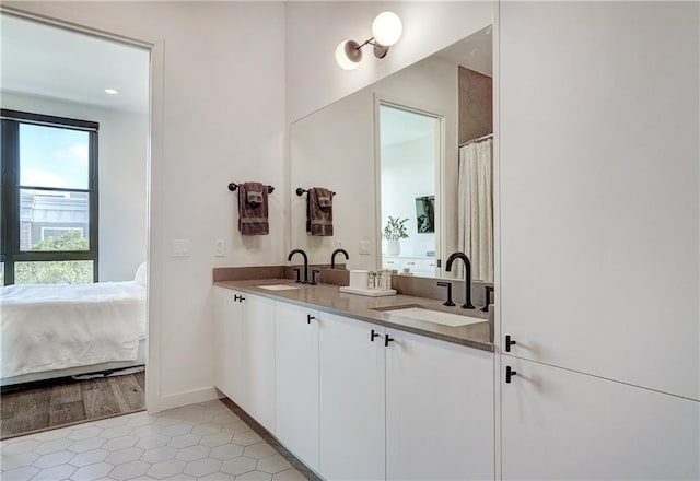 800 Embassy Dr Unit 319, Austin, TX 78702 - bathroom featuring double vanity, tile patterned flooring, baseboards, and connected bathroom