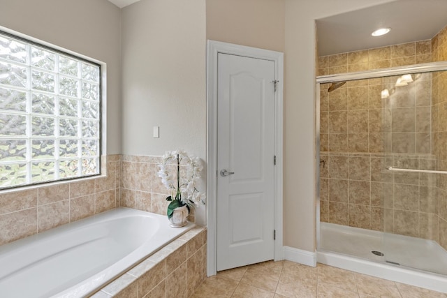 bathroom featuring tile patterned flooring, a bath, and a shower stall